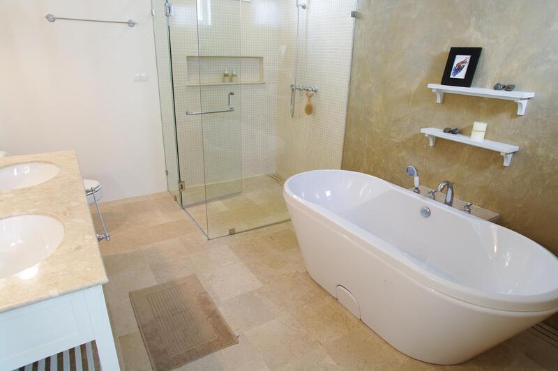 a marbled bathroom with white bathtub